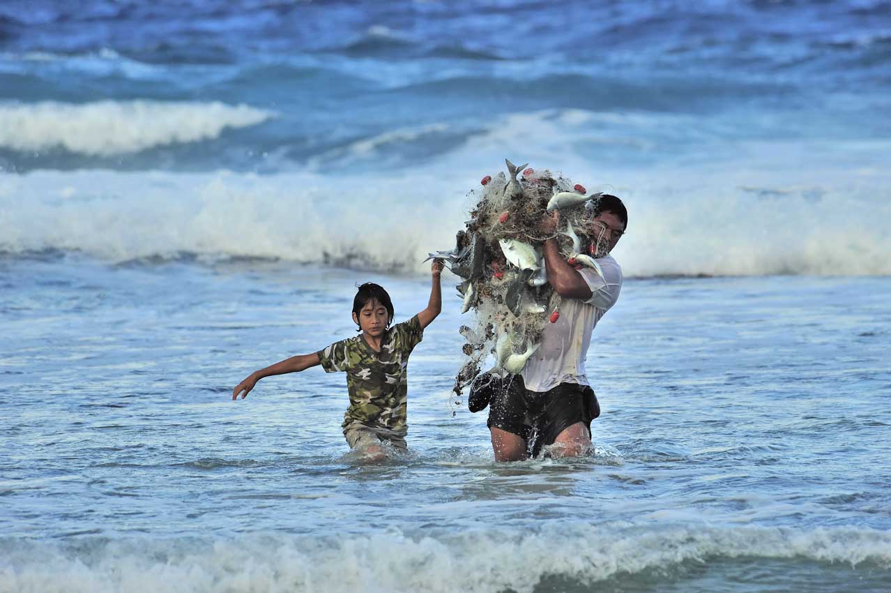 Un pêcheur au filet dans les brisants - Polynésie Française
