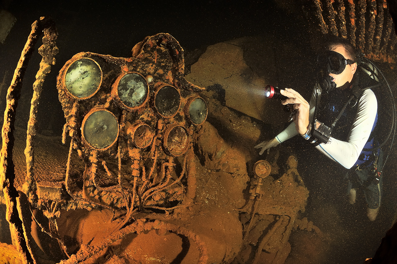 Un plongeur éclaire des jauges dans la salle des machines de l'épave du Nippo Maru - Chuuk Lagoon ou Truk Lagoon
